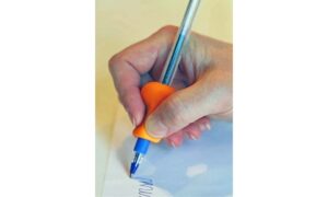 Kynätuki kynässä kirjoittaessa vasemalla kädessä.